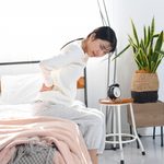 寝起きの腰痛に悩む女性