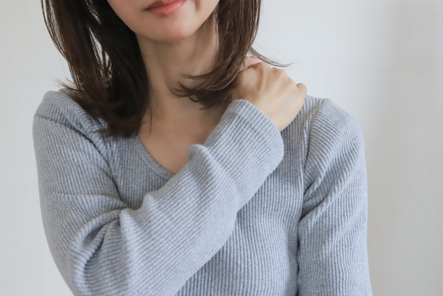 肩に手を当てる女性