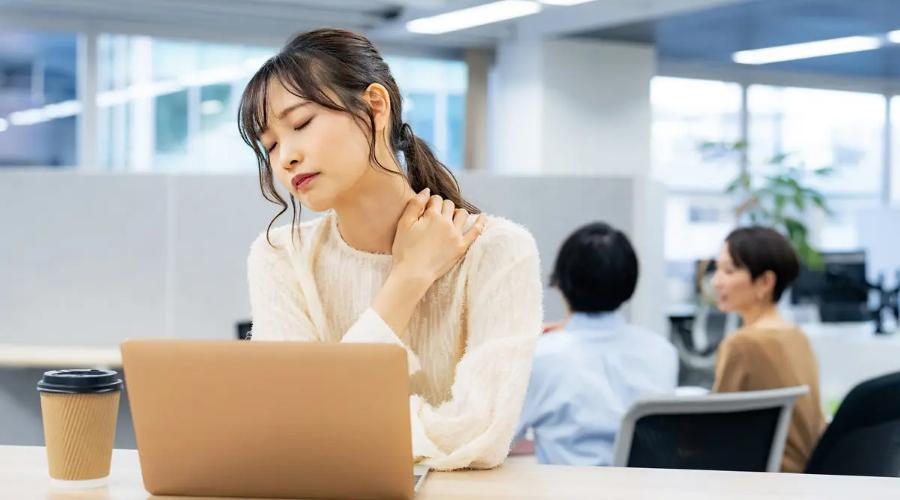 片側の肩こりを感じて肩を押さえる女性